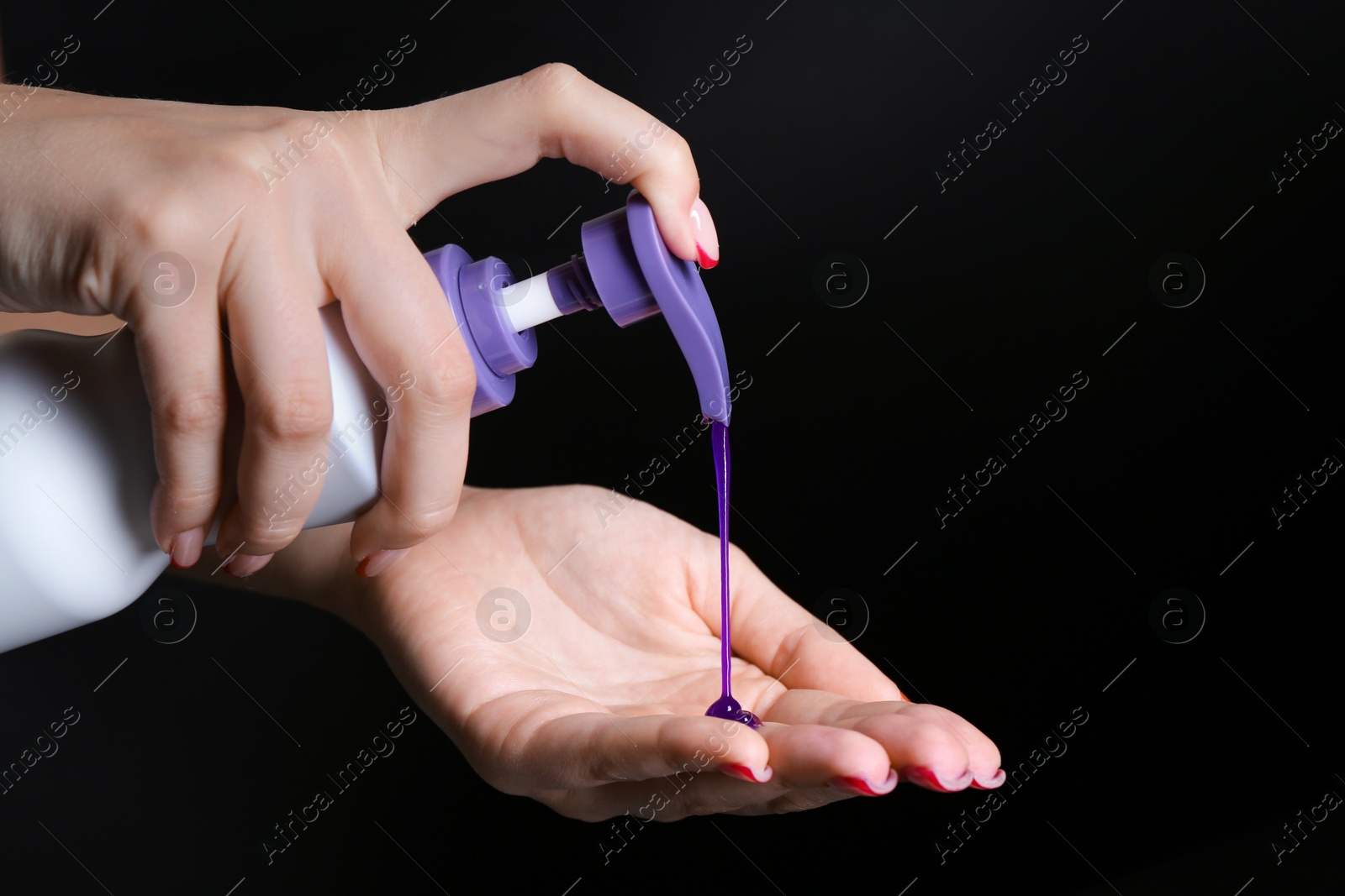 Woman using hair care cosmetic product for blonde hair on black background, closeup. Space for text Photo of Woman using hair care cosmetic product for blonde hair on black background, closeup. Space for text