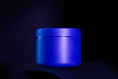 Photo of Jar of hair care cosmetic product for blonde hair on dark background, closeup