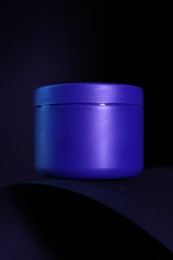 Photo of Jar of hair care cosmetic product for blonde hair on dark background, closeup
