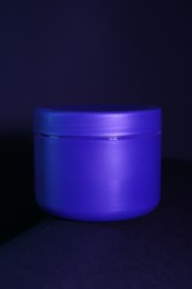 Photo of Jar of hair care cosmetic product for blonde hair on dark background, closeup