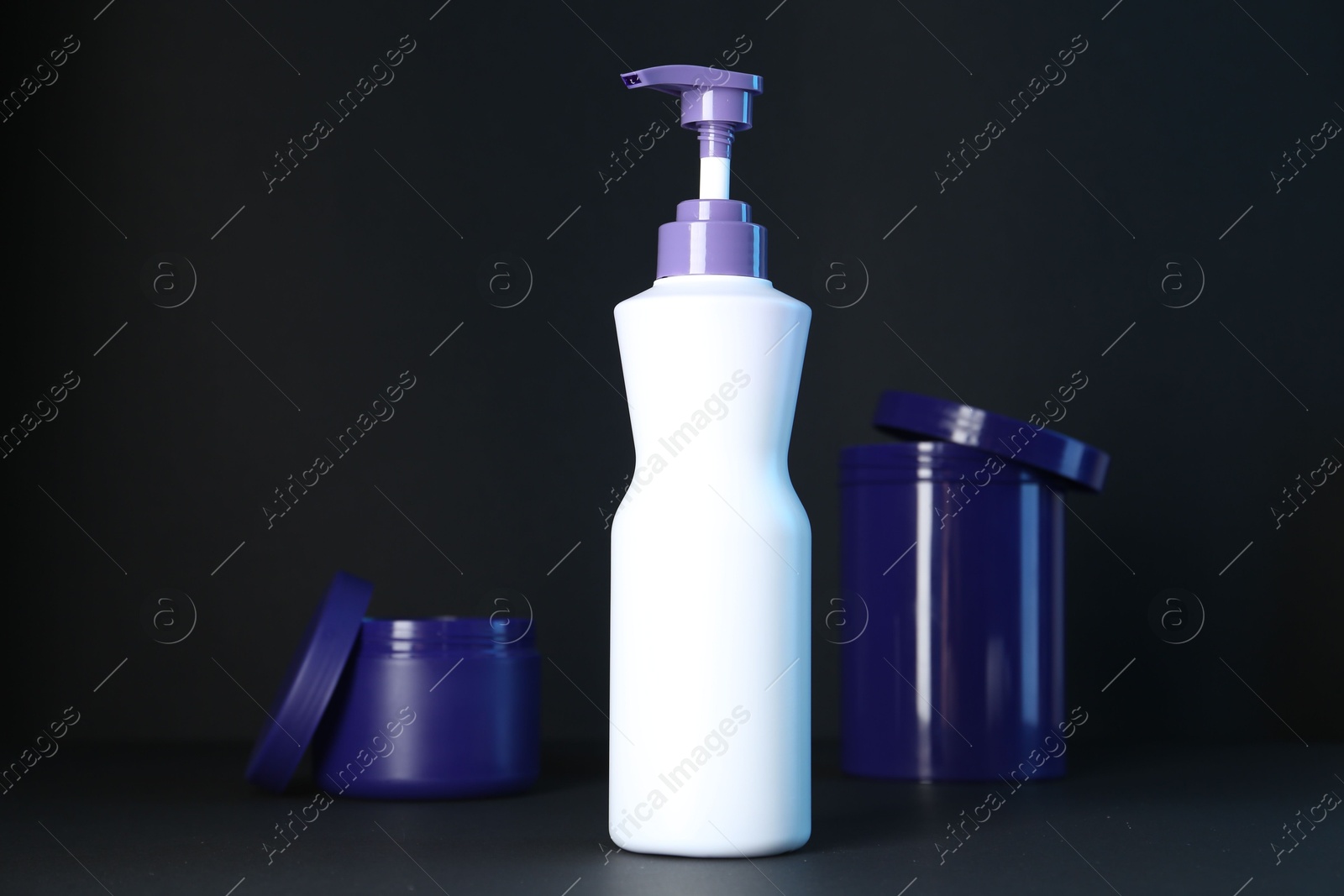 Different hair care cosmetic products for blonde hair on black background Photo of Different hair care cosmetic products for blonde hair on black background