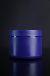 Photo of Jar of hair care cosmetic product for blonde hair on dark background