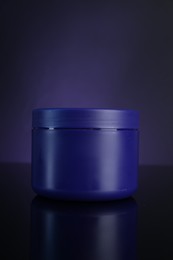 Photo of Jar of hair care cosmetic product for blonde hair on dark purple background