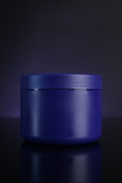 Photo of Jar of hair care cosmetic product for blonde hair on dark background
