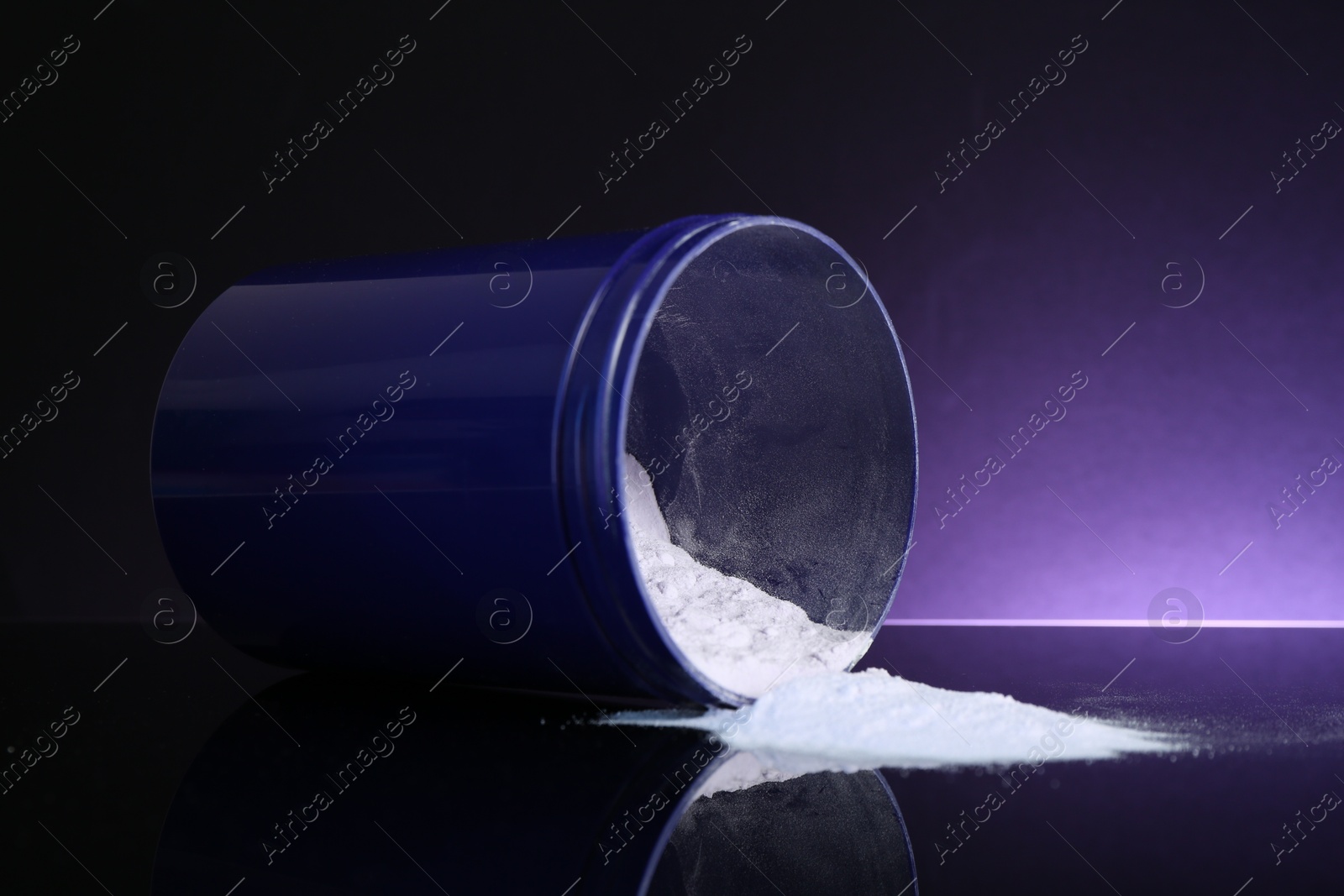 Blonde hair care cosmetic product. Powder in jar on black surface table against dark purple background, closeup Photo of Blonde hair care cosmetic product. Powder in jar on black surface table against dark purple background, closeup
