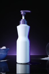 Photo of Hair care cosmetic product for blonde hair and powder on black mirror surface against dark purple background