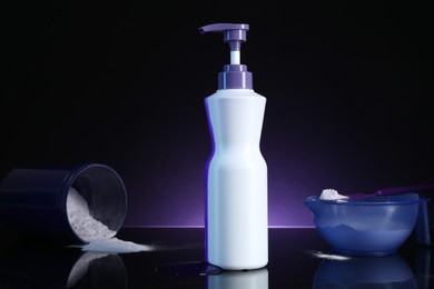 Photo of Hair care cosmetic product for blonde hair and powder on black mirror surface against dark purple background