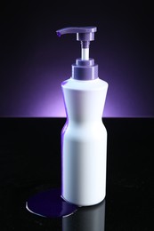 Photo of Bottle of hair care cosmetic products for blonde hair on black mirror surface against dark purple background