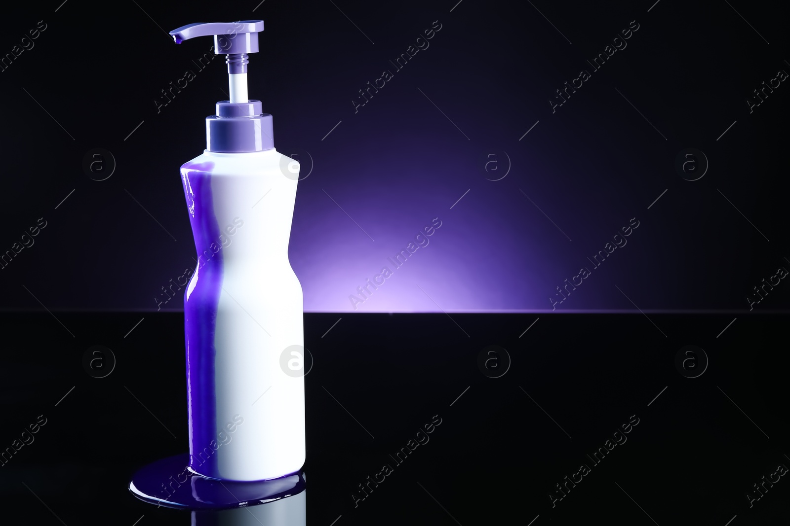 Bottle of hair care cosmetic products for blonde hair on black mirror surface against dark purple background, space for text Photo of Bottle of hair care cosmetic products for blonde hair on black mirror surface against dark purple background, space for text