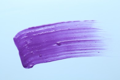 Photo of Sample of blonde hair care cosmetic product on light blue background, top view