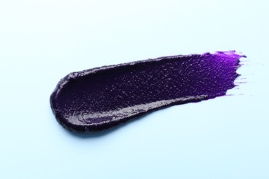 Photo of Sample of blonde hair care cosmetic product on light blue background, top view