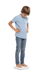 Photo of Little boy standing on scales against white background