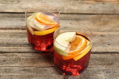 Photo of Fruity punch in glasses on wooden table, closeup. Refreshing drink