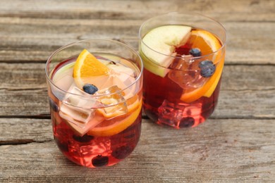 Photo of Fruity punch in glasses on wooden table, closeup. Refreshing drink