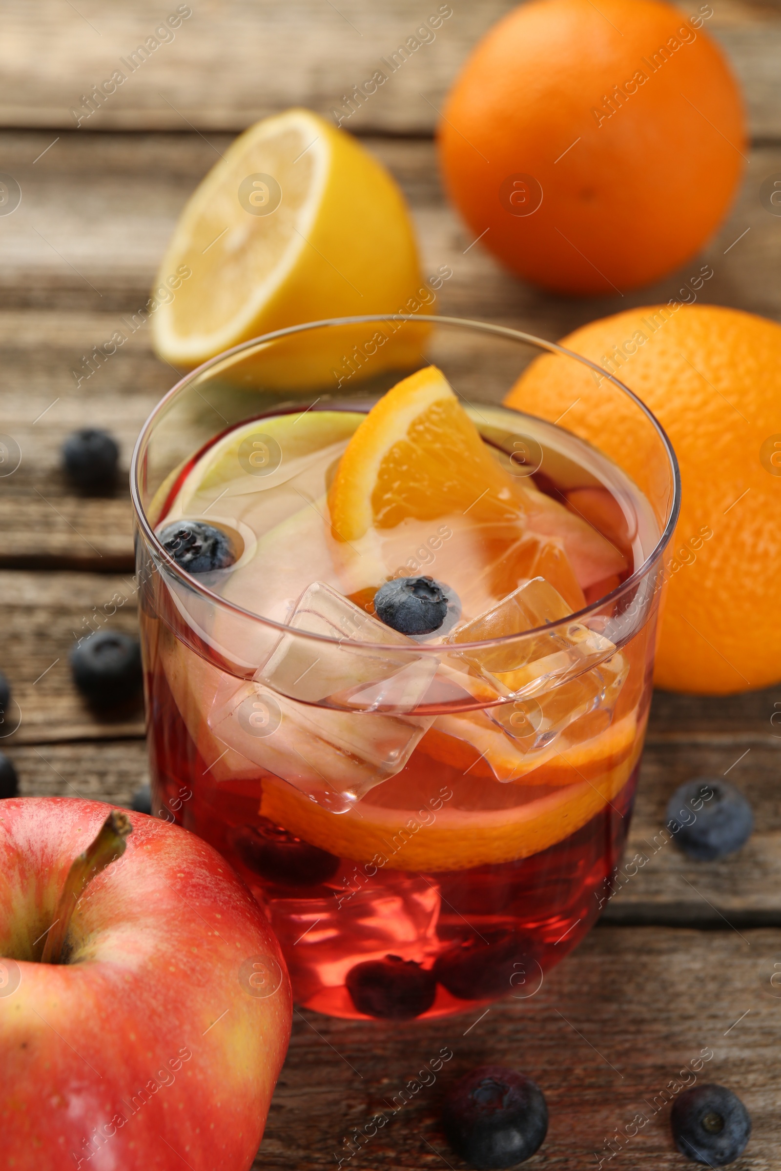 Tasty punch in glass and fresh fruits on wooden table, closeup. Refreshing drink Photo of Tasty punch in glass and fresh fruits on wooden table, closeup. Refreshing drink