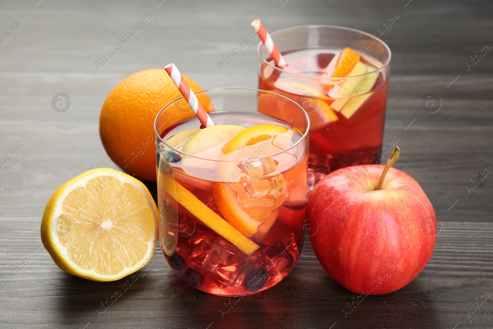 Tasty punch in glasses and fresh fruits on wooden table, closeup. Refreshing drink Photo of Tasty punch in glasses and fresh fruits on wooden table, closeup. Refreshing drink