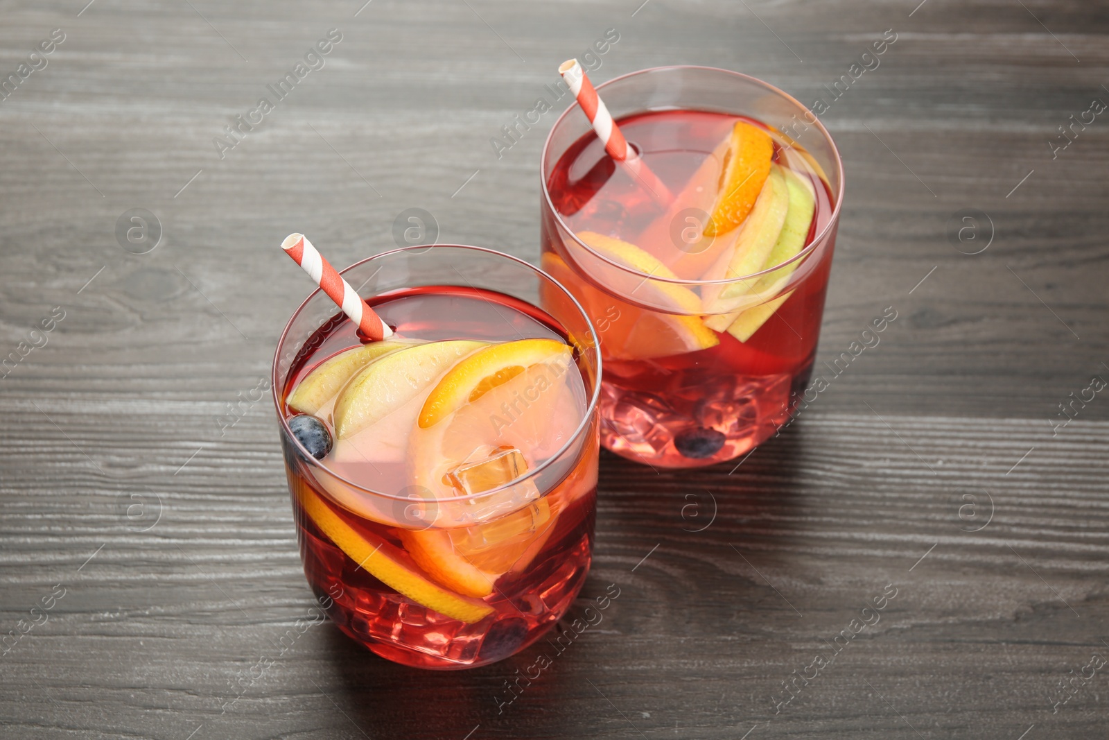 Fruity punch in glasses on wooden table, closeup. Refreshing drink Photo of Fruity punch in glasses on wooden table, closeup. Refreshing drink