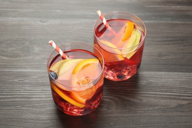 Photo of Fruity punch in glasses on wooden table, closeup. Refreshing drink