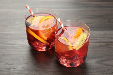 Photo of Fruity punch in glasses on wooden table, closeup. Refreshing drink