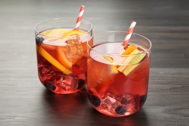 Photo of Fruity punch in glasses on wooden table, closeup. Refreshing drink