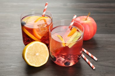 Photo of Tasty punch in glass and fresh fruits on wooden table. Refreshing drink