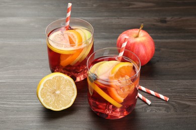 Photo of Tasty punch in glass and fresh fruits on wooden table. Refreshing drink
