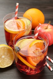 Photo of Tasty punch in glass and fresh fruits on wooden table. Refreshing drink