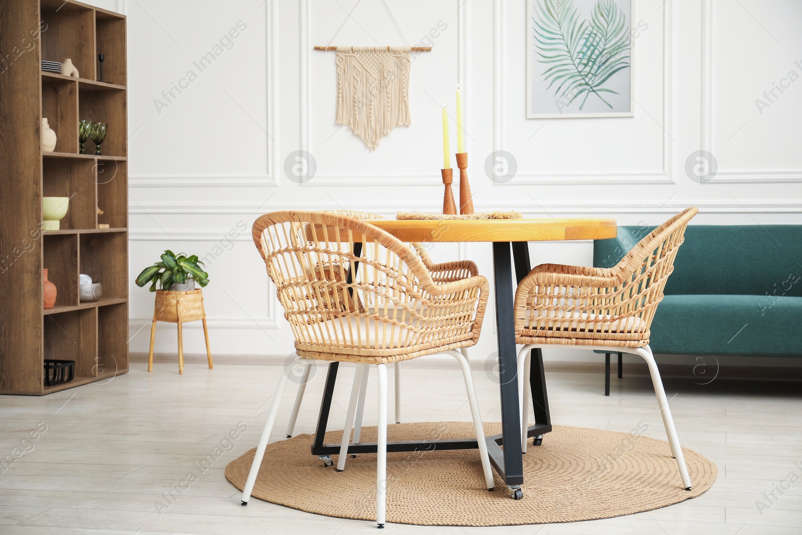 Photo of Wooden table with candles and stylish chairs in dining room