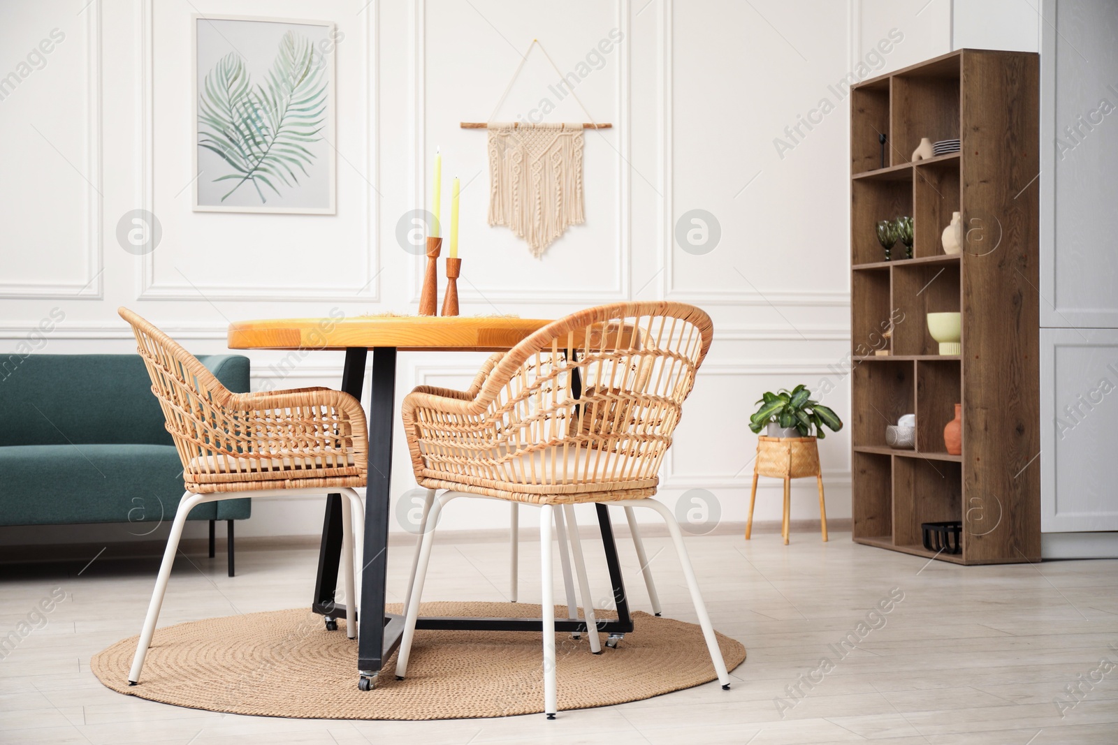 Photo of Wooden table with candles and stylish chairs in dining room
