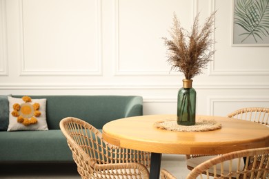 Photo of Wooden table with decor and stylish chairs in dining room