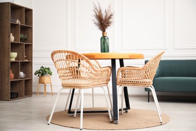 Photo of Wooden table with decor and stylish chairs in dining room