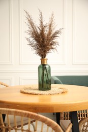Photo of Wooden table with decor and stylish chairs in dining room, closeup