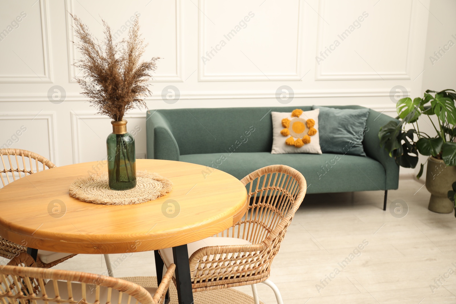 Wooden table with decor and stylish chairs in dining room Photo of Wooden table with decor and stylish chairs in dining room