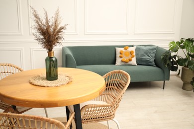 Photo of Wooden table with decor and stylish chairs in dining room