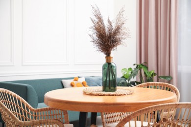 Photo of Wooden table with decor and stylish chairs in dining room, closeup