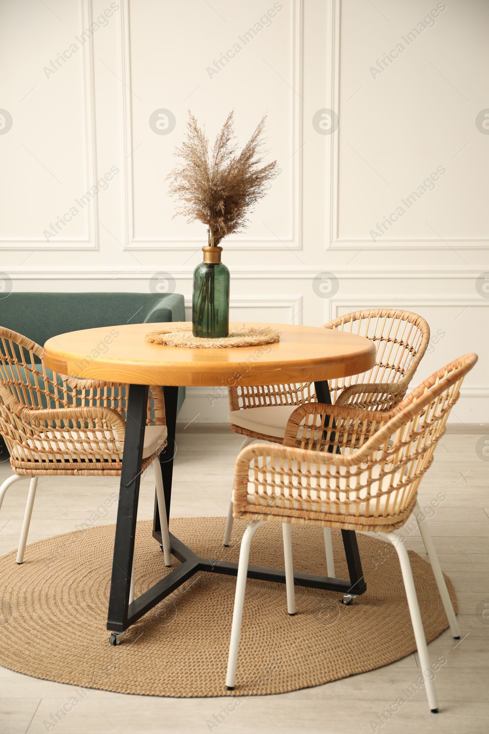 Photo of Wooden table with decor and stylish chairs in dining room