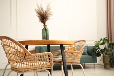 Photo of Wooden table with decor and stylish chairs in dining room