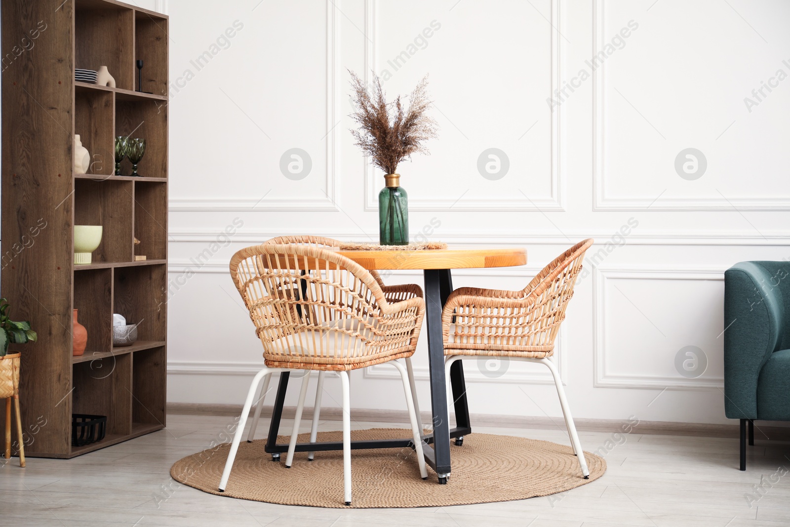 Wooden table with decor and stylish chairs in dining room Photo of Wooden table with decor and stylish chairs in dining room