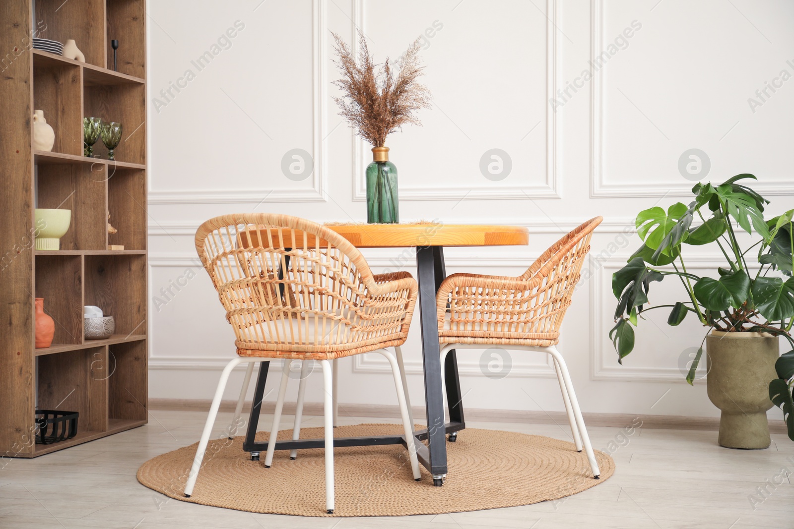 Wooden table with decor and stylish chairs in dining room Photo of Wooden table with decor and stylish chairs in dining room