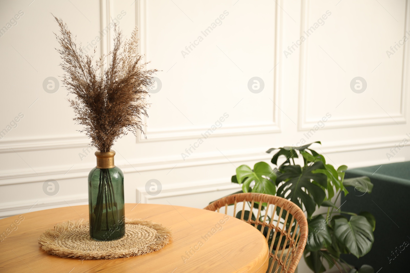 Photo of Wooden table with decor and stylish chair in dining room, closeup