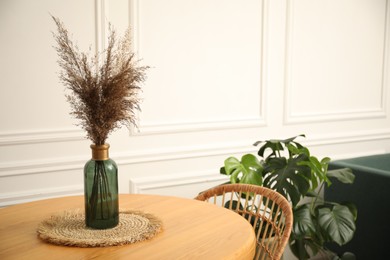Photo of Wooden table with decor and stylish chair in dining room, closeup
