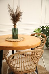 Photo of Wooden table with decor and stylish chairs in dining room