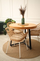 Photo of Wooden table with decor and stylish chairs in dining room