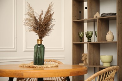 Photo of Wooden table with decor and stylish chairs in dining room, closeup