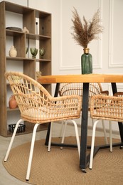 Photo of Wooden table with decor and stylish chairs in dining room