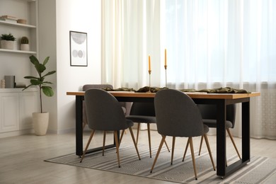 Photo of Decorated wooden table with chairs in dining room