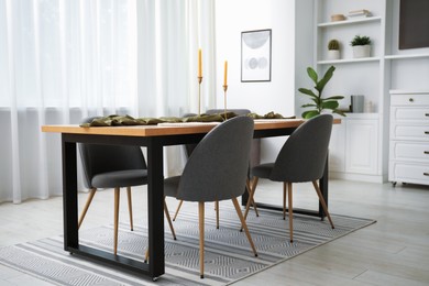 Photo of Decorated wooden table with chairs in dining room