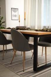 Photo of Decorated wooden table with chairs in dining room