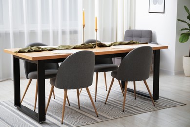 Photo of Decorated wooden table with chairs in dining room