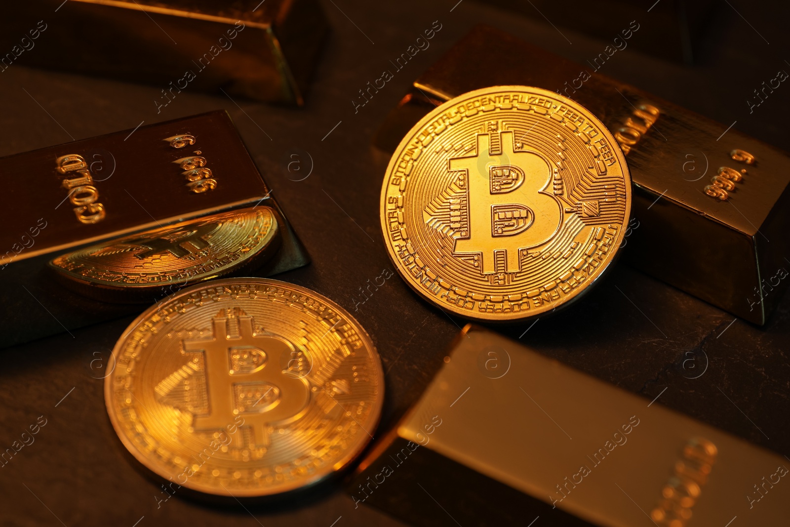 Photo of Cryptocurrency. Golden bitcoins and gold bars on black table, closeup